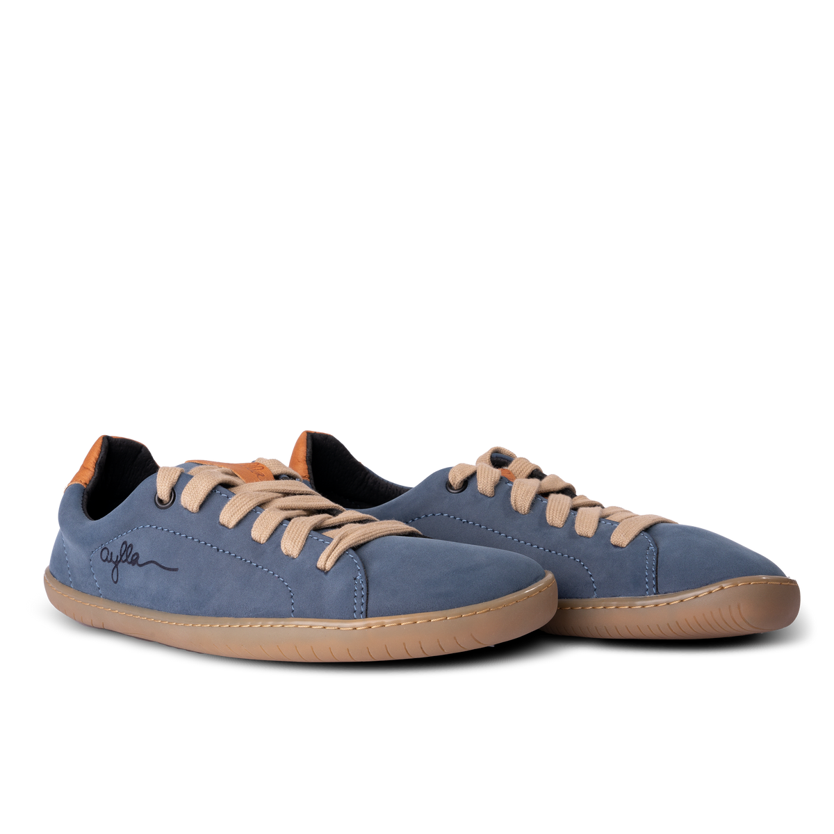 Par blå sneakers med naturfarvet sål skråt forfra