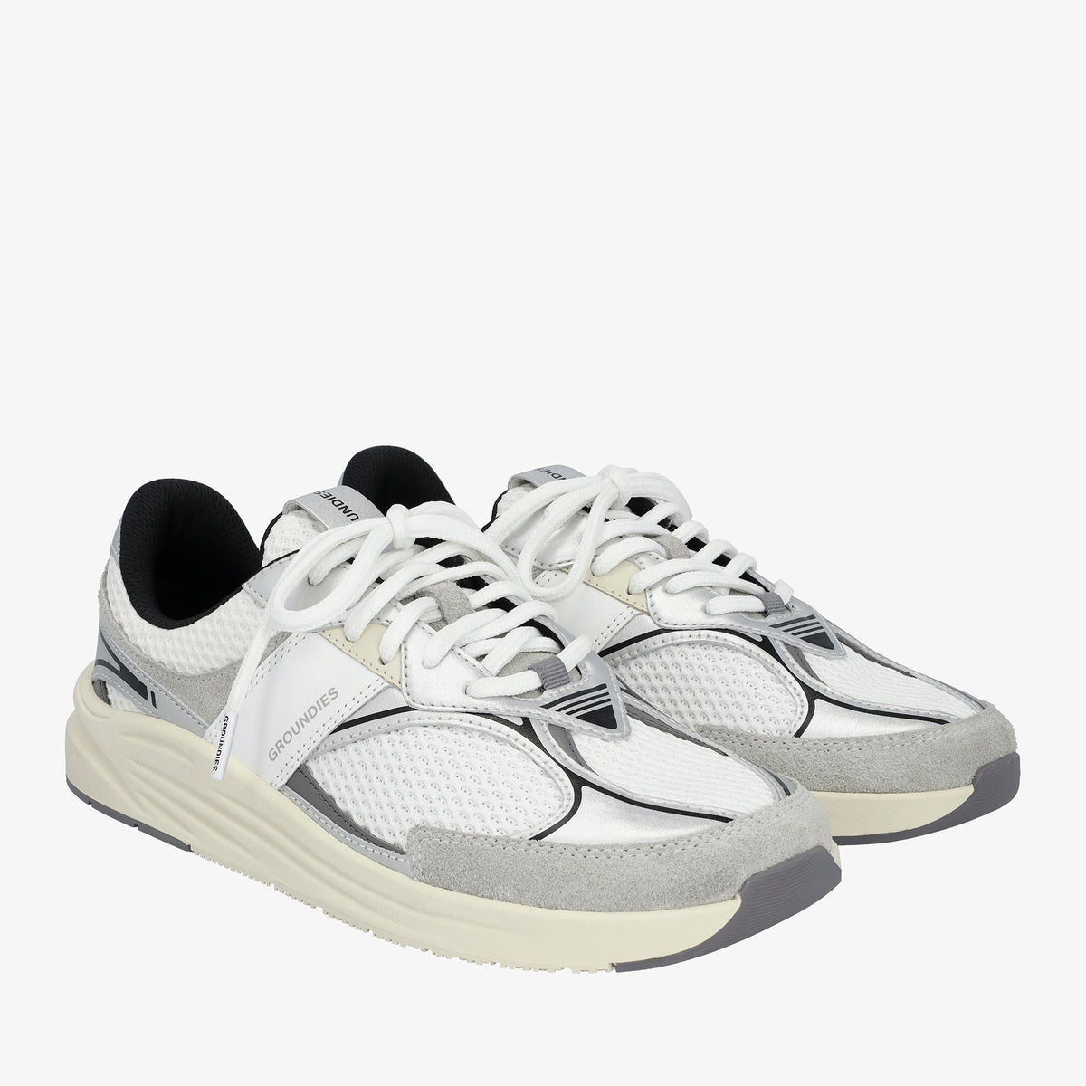 Par hvide og sølvfarvede sneakers med grå ruskind set skråt forfra
