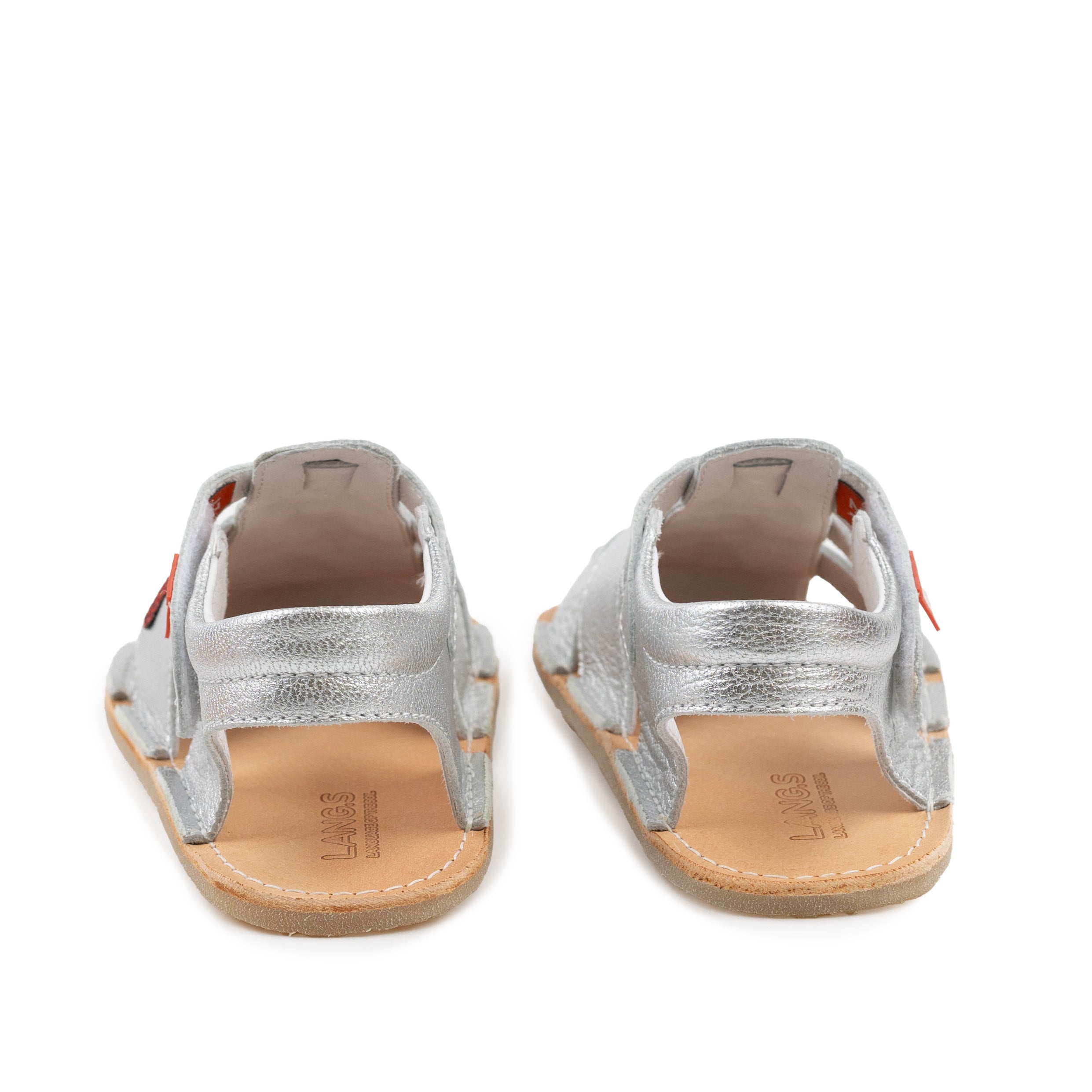 Bagsiden af unisex børnesandaler fra Tikki Lasta Leather, variant Cuore, i skinnende sølv med naturlæder indersål og justerbare remme. Komfortabel og fleksibel pasform.