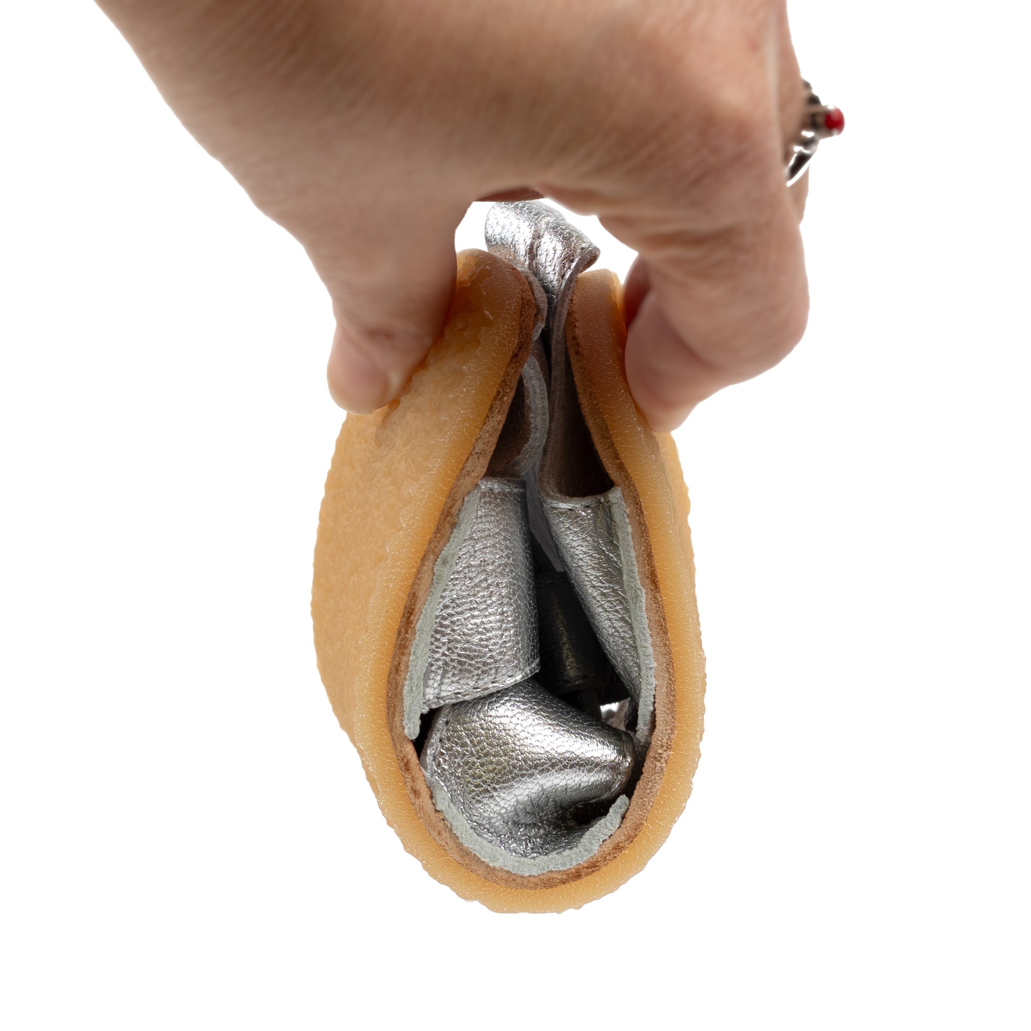 Tikki Lasta Leather Cuore kids' shoes in silver leather, shown rolled to showcase flexibility. Natural rubber soles are visible, emphasizing barefoot design. Unisex footwear.