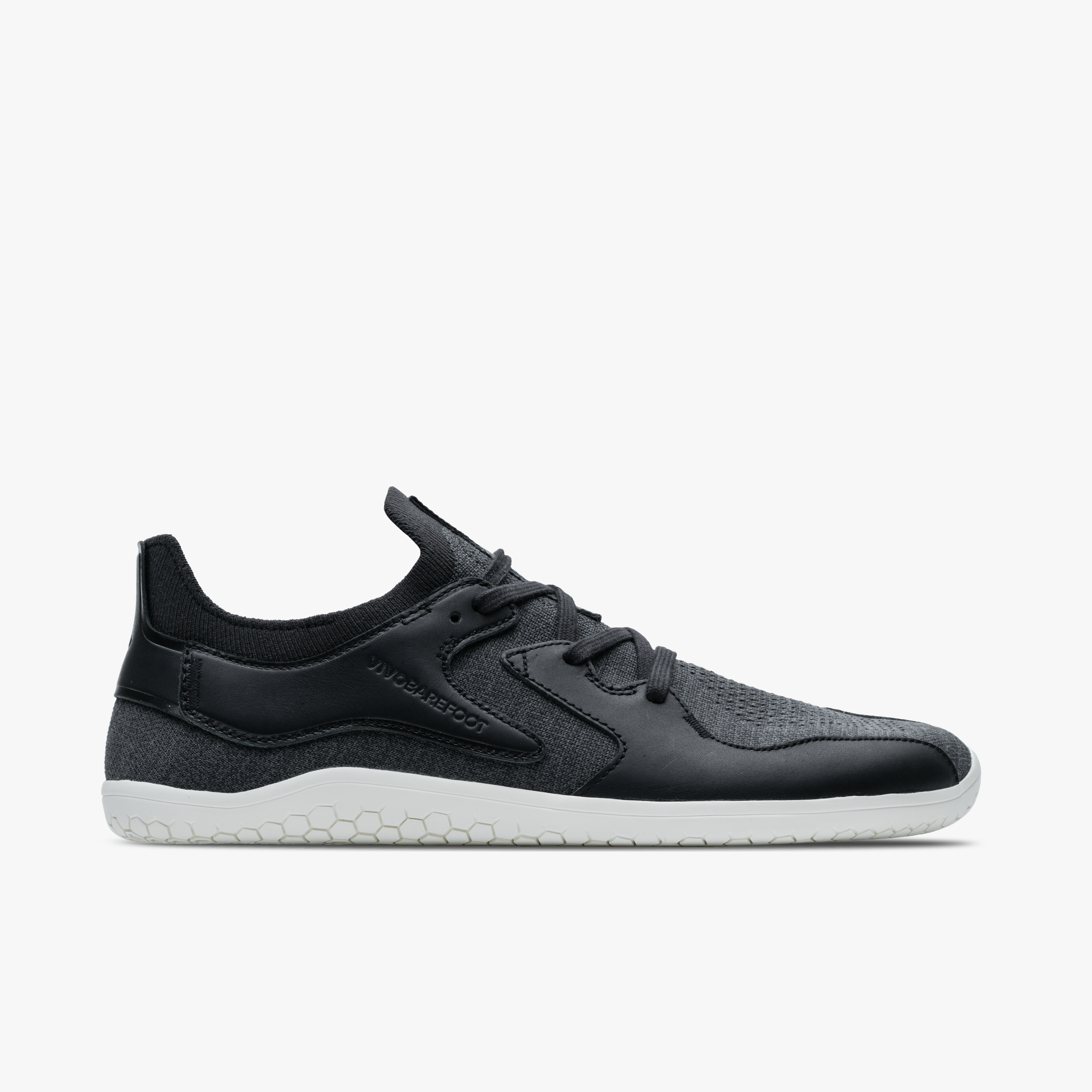 Vivobarefoot Asana III i varianten Obsidian, barfodssko til mænd, viser et strømlinet design med mørkegrå tekstureret overdel og en markant hvid ydersål.