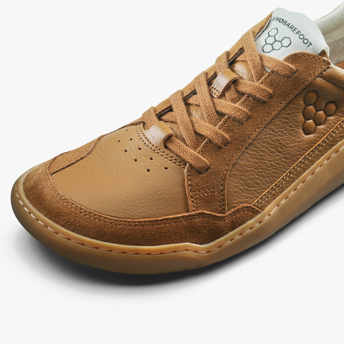 Nærbillede af snørebånd og perforeret tåparti på tan lædersneaker