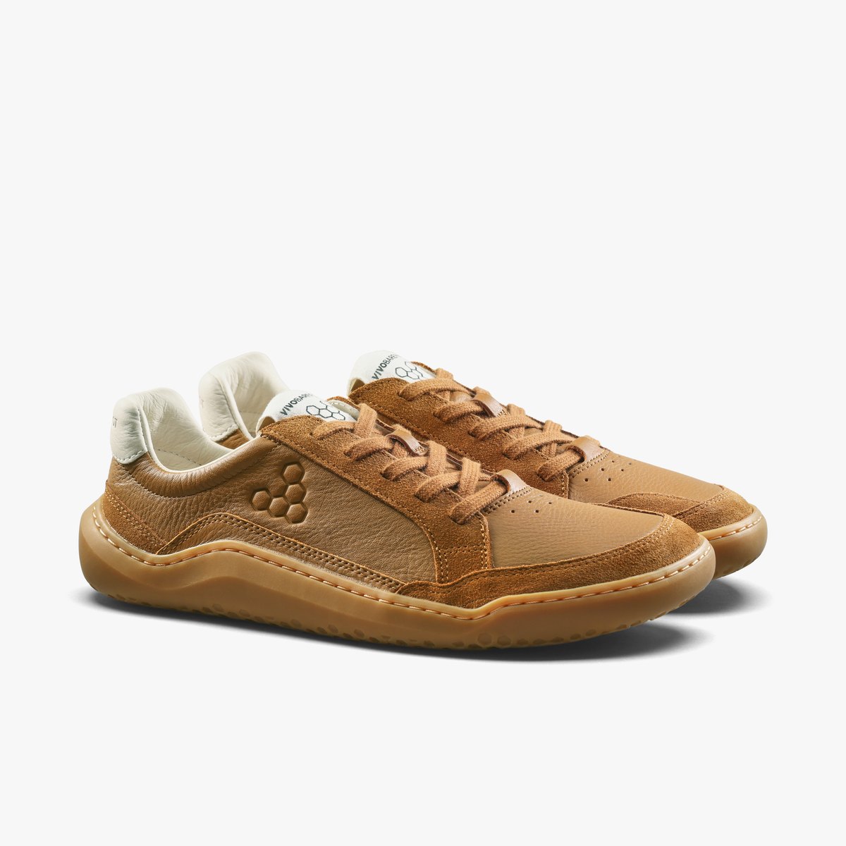 Par lave sneakers i tan med lyse hælstykker set skråt forfra
