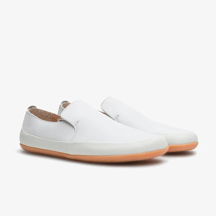 Hvide slip-ons som par set skråt forfra