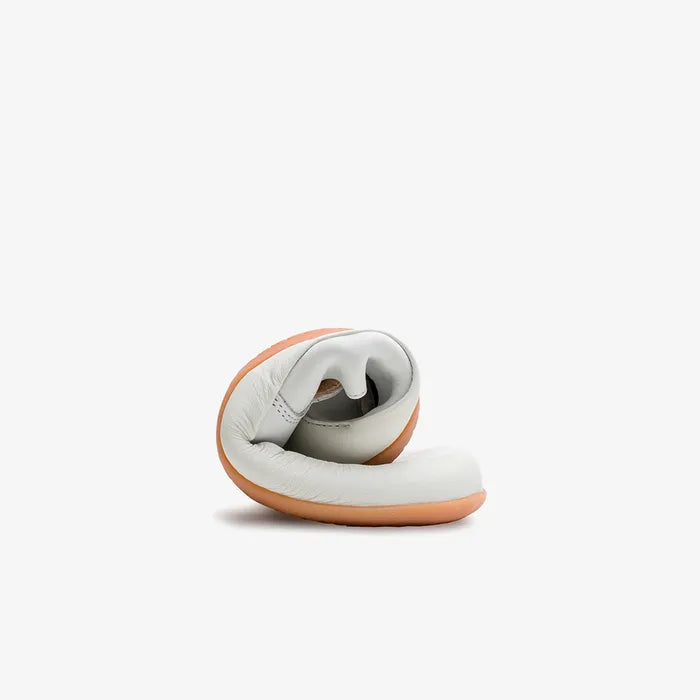 Sammenrullet hvid slip-on viser den fleksible sål