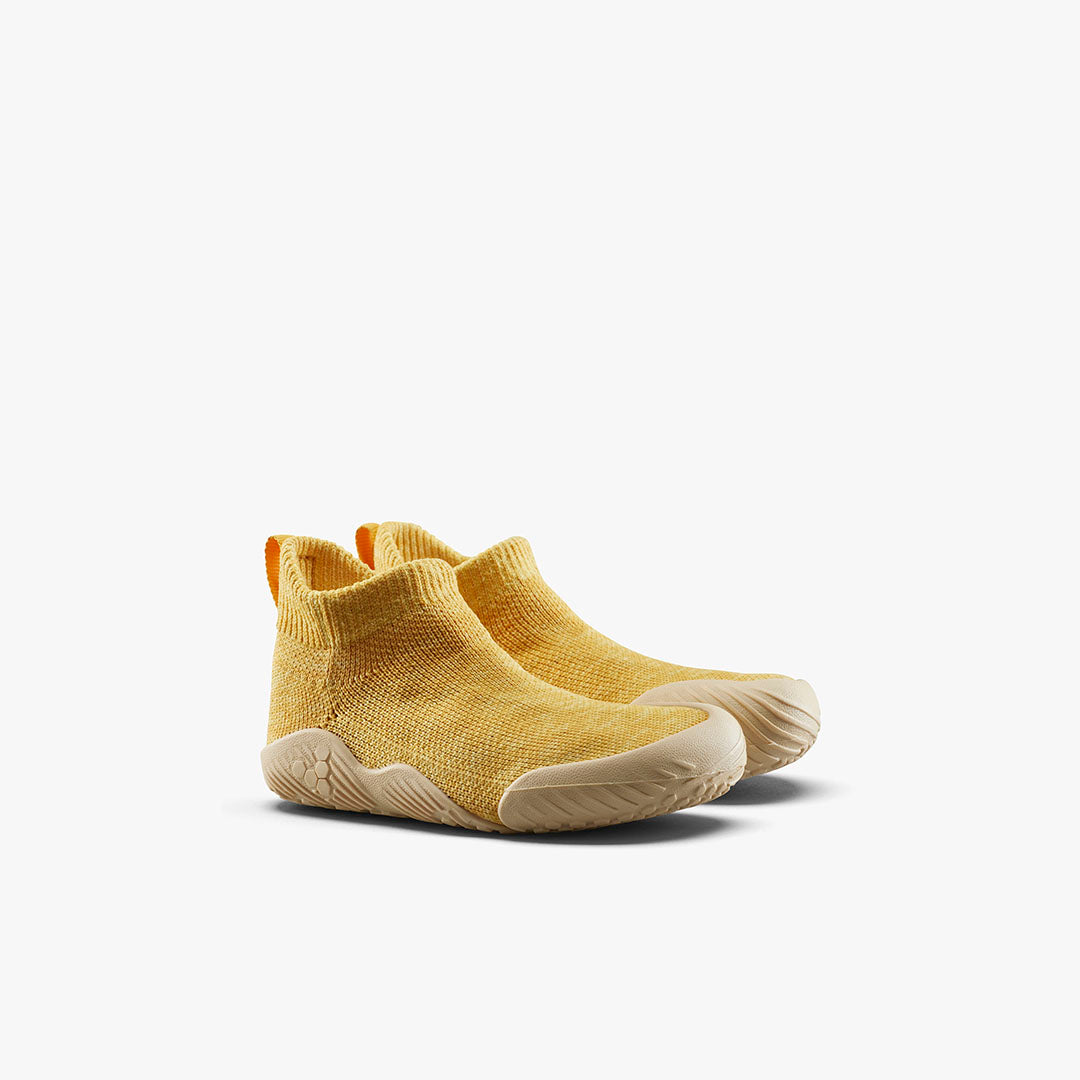 Vivobarefoot Pluma Knit Toddlers sko i Honey Gold. Fleksibelt strik, ultratynd NatureFlex sål med bikubemønster. Terrakottafarve og orange hælstrop for nem påtagning.