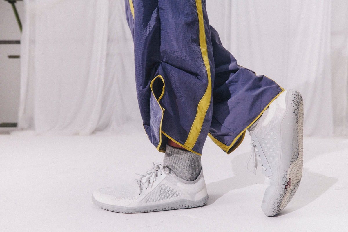Kvinde går i lette barfodssko med snørebånd, nærbillede af fødderne
