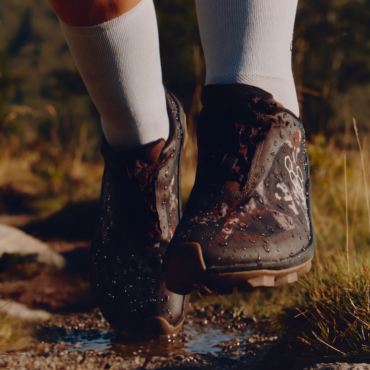 Trailsko i Mole Print på fod i en vandpyt på en stenet sti