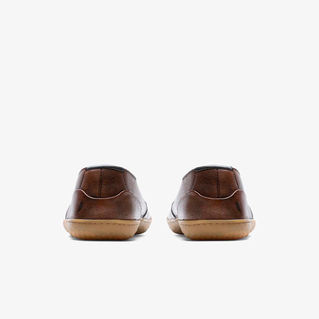 Vivobarefoot Ra III Lux Mens sko i Tan variant ses bagfra. Disse barefoot sko har en brun, glat læderoverdel og afrundet hæl, ideel til både arbejde og fritid.