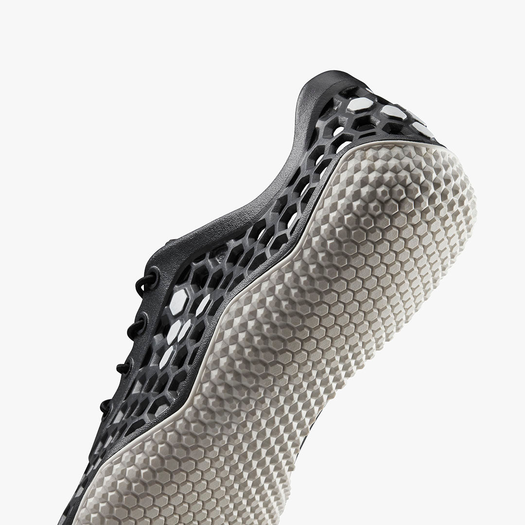 Vivobarefoot Ultra IV Womens sneaker i varianten Obsidian, med sort bikubemønster og lysegrå sål, der fremhæver stil og funktionalitet i minimalistiske sko.