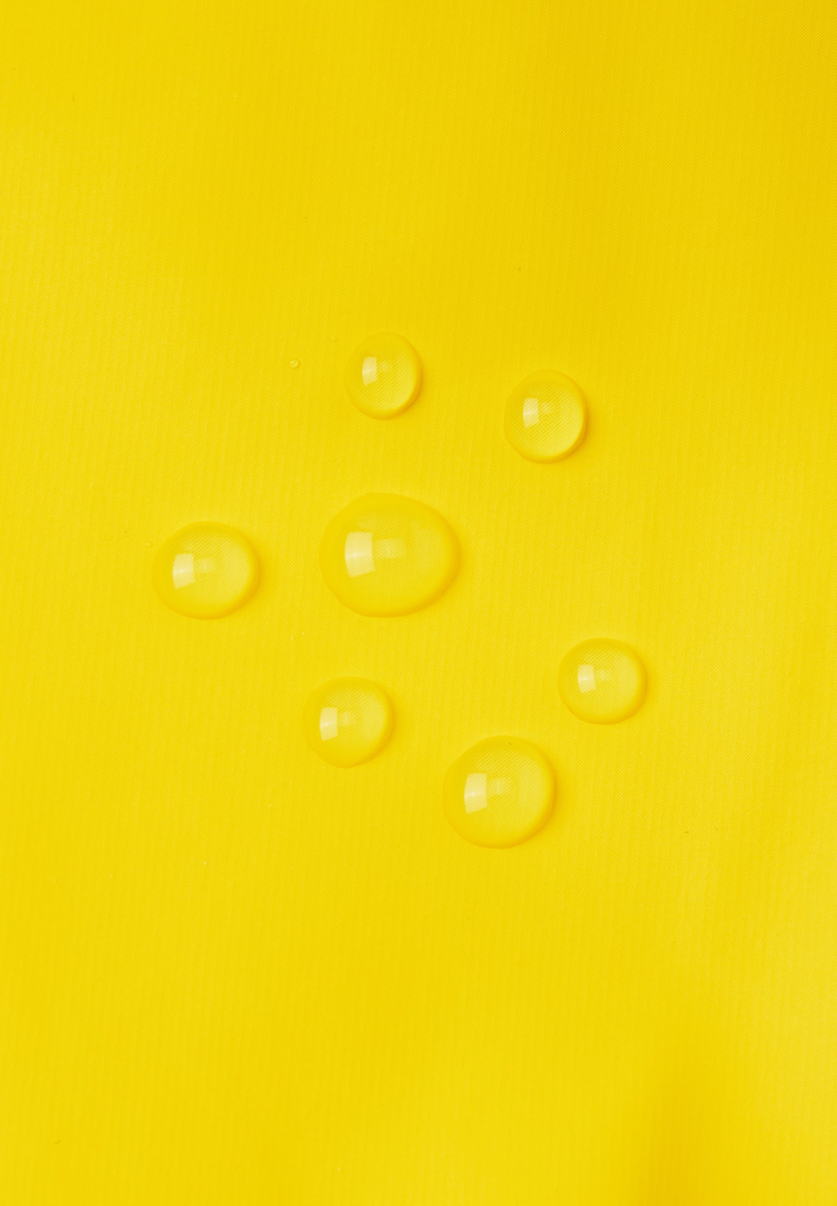 Reima Puro regnhandsker til børn i Yellow, nærbillede af det vandtætte materiale med vanddråber