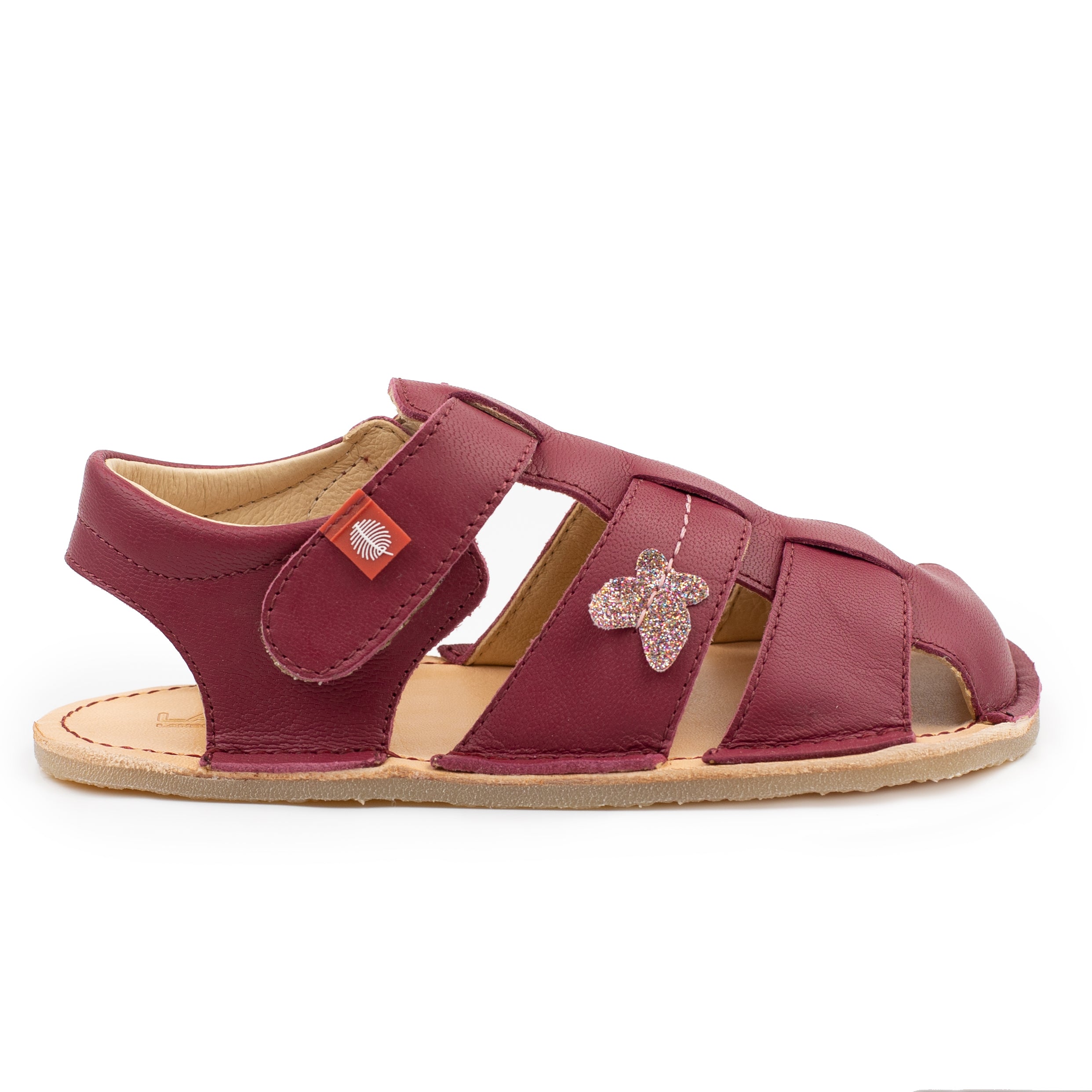 Børnesandal fra Tikki Lasta Leather, Farfalla variant, i burgundy læder med glitter sommerfugl dekoration og lysebrun fleksibel sål. Åben tå design med justerbar rem.