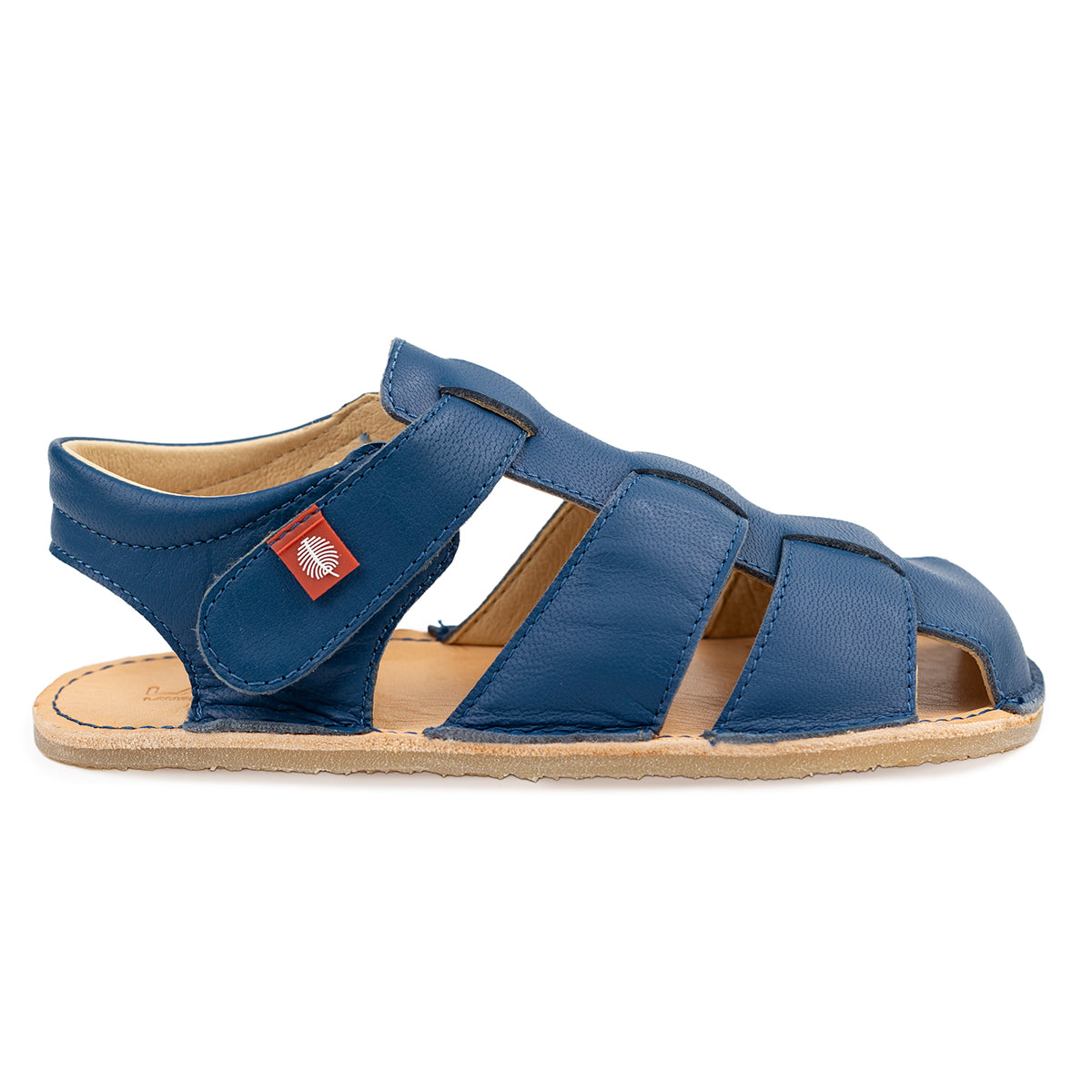 Tikki Lasta Leather Mare børnesandal i dyb blå med flere læderremme, åben tå og en naturlig lædersål for en barfodseffekt, med rød mærkat på siden.