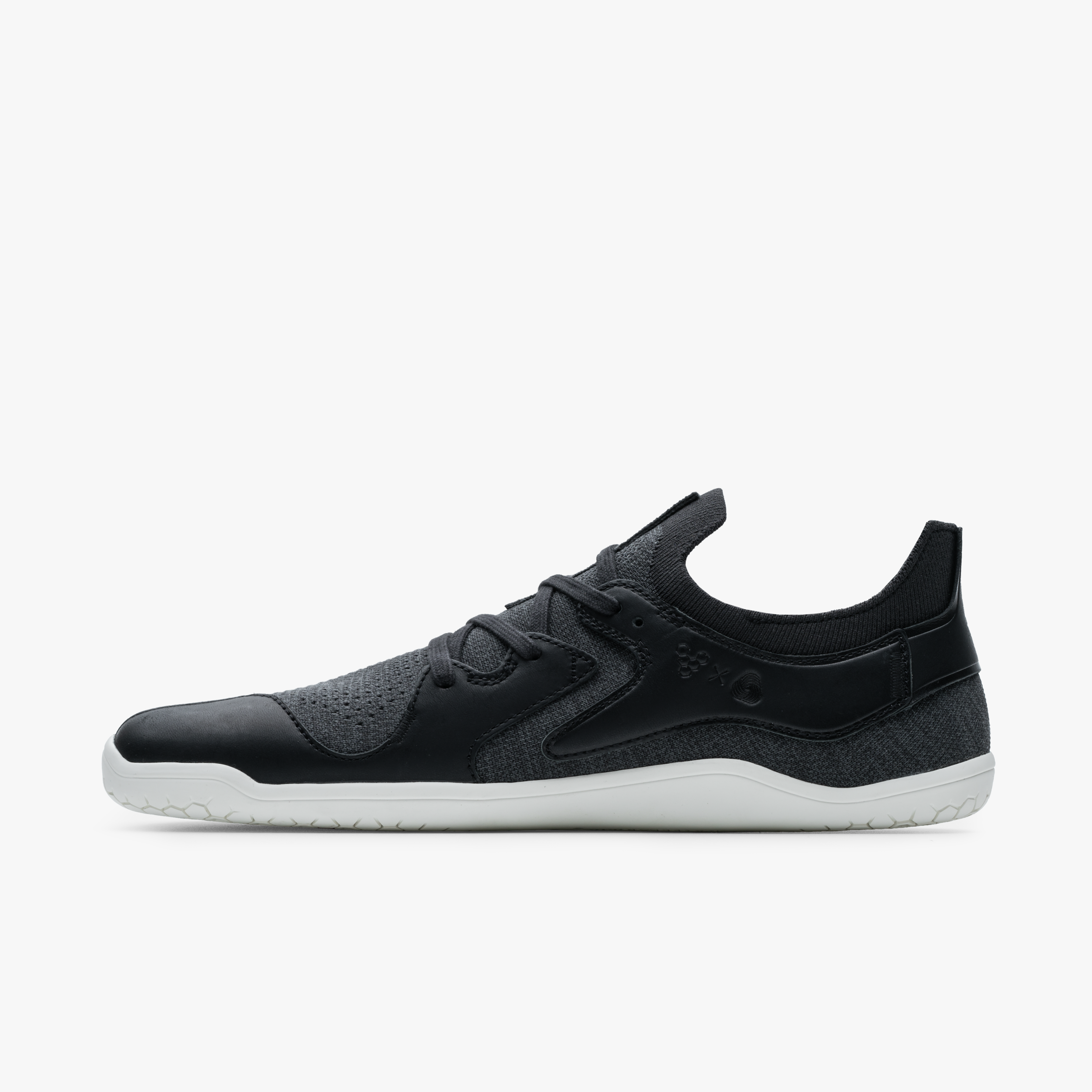 Barfodssneakers, Vivobarefoot Asana III i varianten Obsidian, viser siden indvendigt. Designet forener minimalistisk stil og naturlig fodfrihed i en mørk, tekstureret overdel med hvid ydersål.