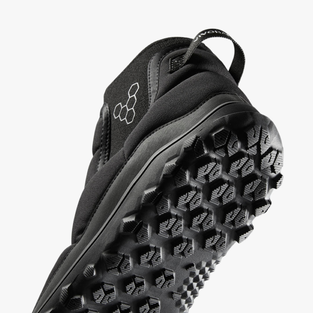 Vivobarefoot Explorer Mid Womens i varianten Obsidian. Detaljeret visning af sålens solide, sekskantede mønster for bedre greb. Minimalistisk sort design med logo på oversiden.