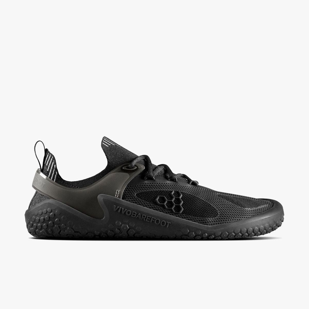 Vivobarefoot Motus Strength Womens i varianten Obsidian, barfodssko designet til sport, viser siden, med letvægtsstrukturelle detaljer og grebsmønstret sål.