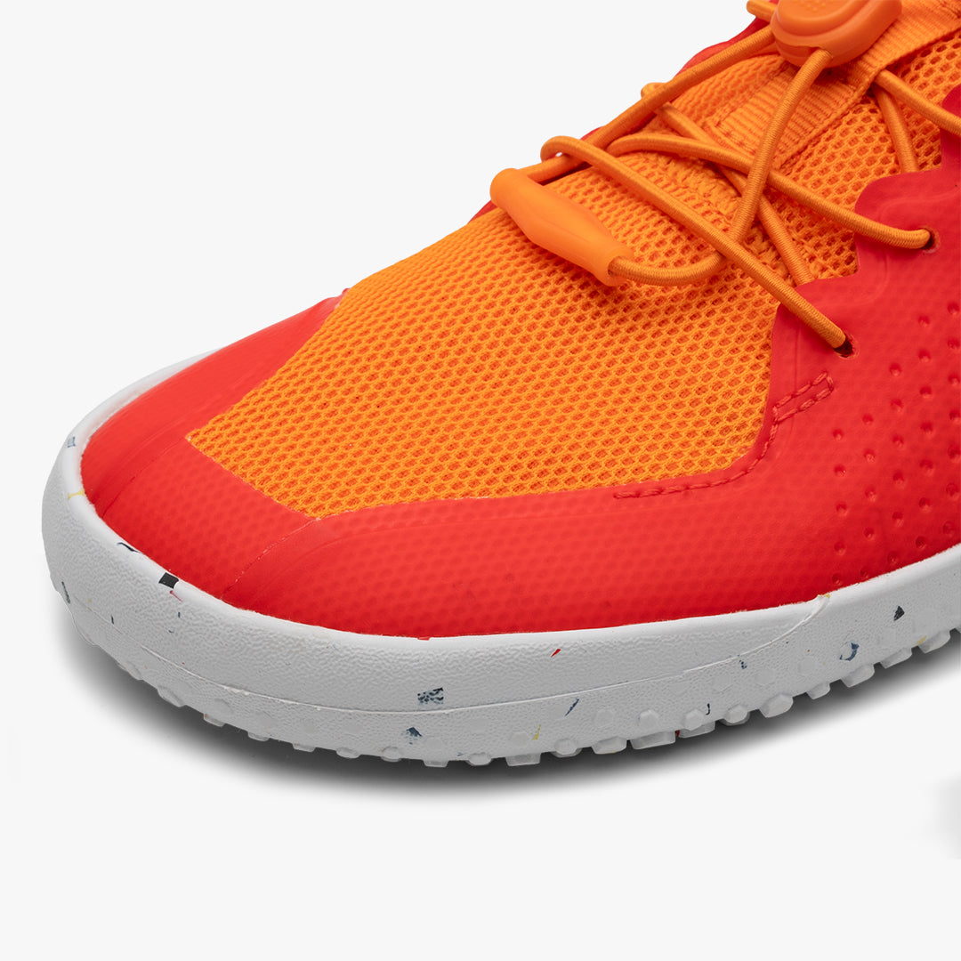 Vivobarefoot Primus Sport III Juniors barefoot shoe in Cherry Tomato. Orange mesh with red accents, white speckled sole, toggle lacing system. Lightweight design for natural movement.